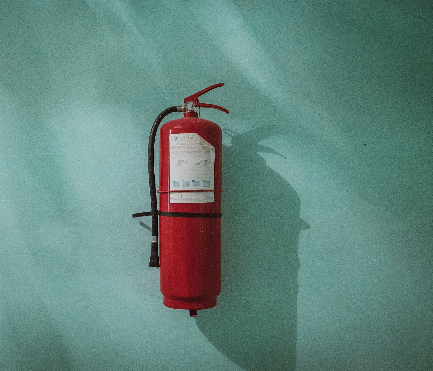 A red fire extinguisher mounted on a wall (stock photo)