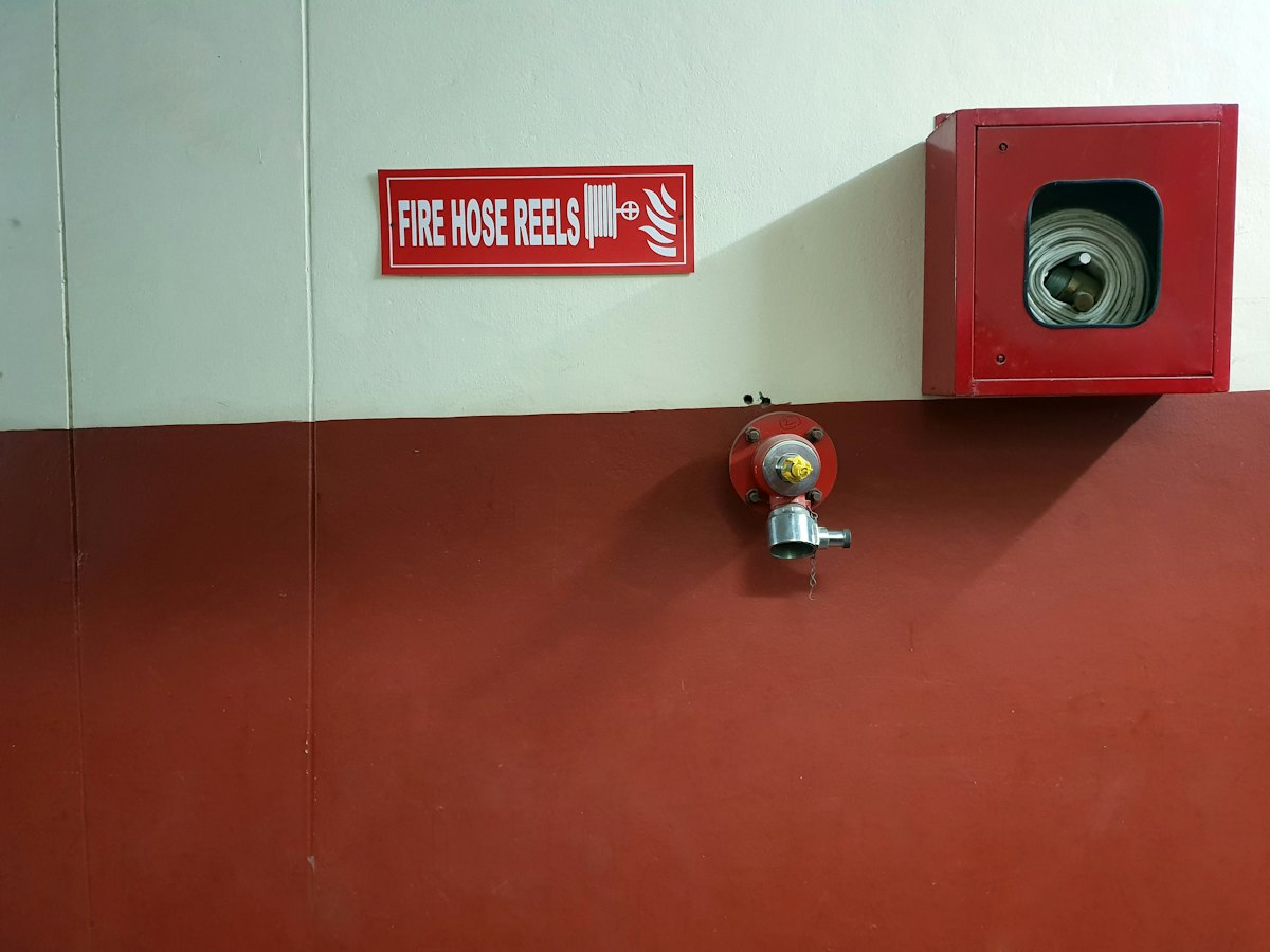 A fire hose reel cabinet and sign on a wall (stock photo)